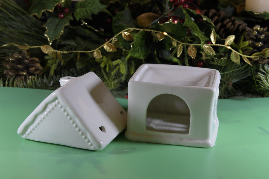 White Gingerbread House Oil Burner. This beautifully detailed ceramic piece works with both fragrance oils and wax melts, filling your space with delightful scents while adding a whimsical, cottage-inspired accent to your decor.