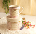 Pink ceramic mug with floral design and bow detail featuring 'Mum you mean the world to me' message"