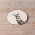 White ceramic coaster with hare holding daisy sketch, matches hare jug